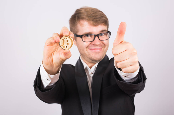 ευτυχισμένος άνθρωπος κρατώντας μεγάλα bitcoin και δείχνει τους αντίχειρες επάνω - Φωτογραφία, εικόνα