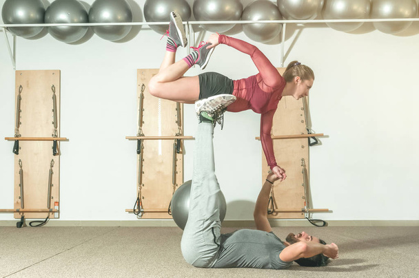 Young beautiful fitness couple workout extreme acrobatic exercise as preparation for the competition, selective focus - Fotografie, Obrázek