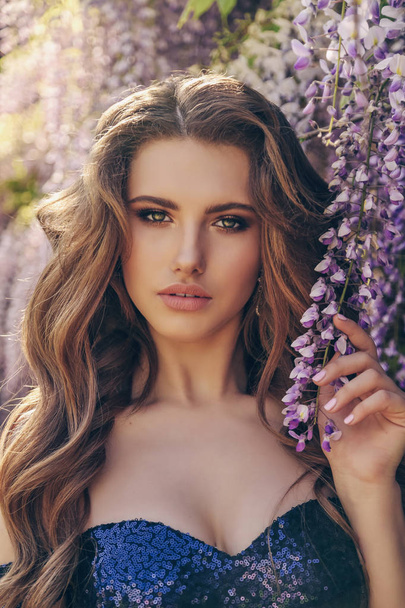 woman with long hair in luxurious dress posing among flowering w - Photo, Image