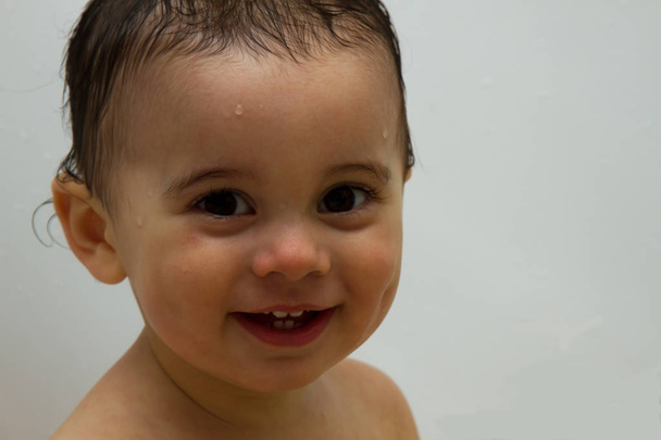 schönes Baby, ein Jahr alt, draußen mit nassen Haaren. Bad. auf weißem Hintergrund - Foto, Bild