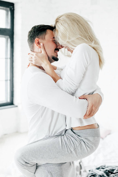 Man holding his wife in his arms and kissing her. Indoor - Foto, Imagen