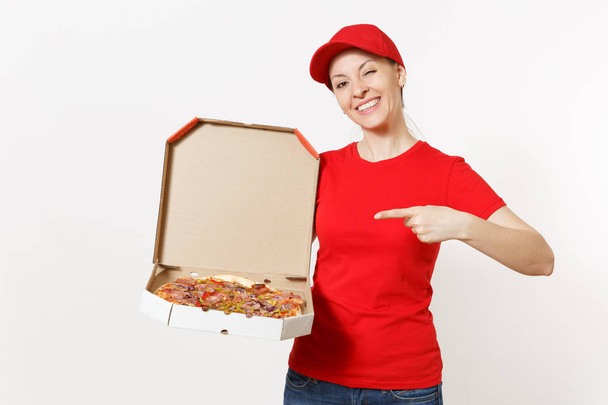 Delivery woman in red uniform isolated on white background. Pretty female in cap, t-shirt, jeans working as courier or dealer holding italian pizza in cardboard flatbox. Copy space for advertisement. - Photo, Image