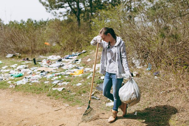 Szomorú nő alkalmi ruhák, takarítás szemetet gazdaság táskák ferde  - Fotó, kép