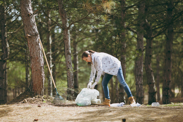 Jeune femme en vêtements décontractés, gants de nettoyage des déchets dans les tras
 - Photo, image