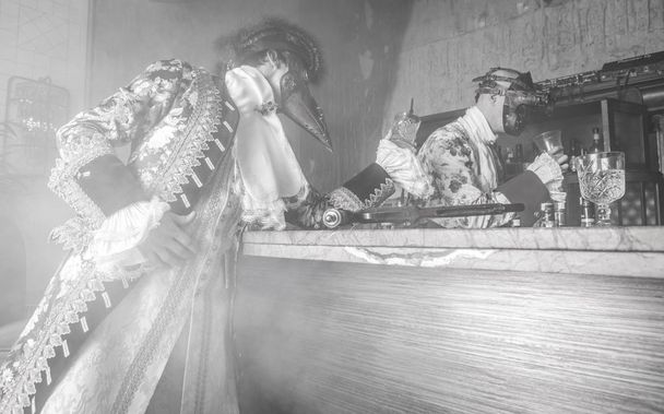 Actors in Steam punk masks and antique costumes indoor. Black-white photo. - Фото, изображение