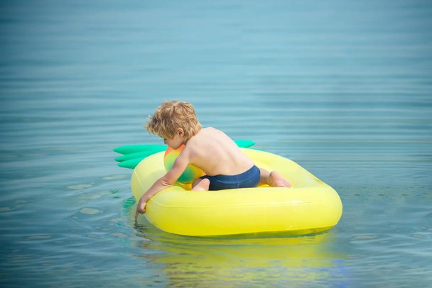 little kid on Caribbean sea in Bahamas. little kid swim on yellow onflatable mattress in sea water. - Photo, Image