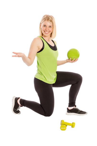 Beautiful young woman in bright sportswear with ball and dumbbel - Foto, afbeelding