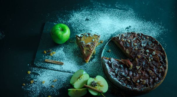 Яблочный пирог с карамельным кремом на черном столе
 - Фото, изображение