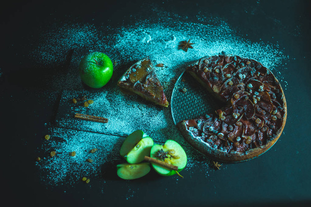 Яблочный пирог с карамельным кремом на черном столе
 - Фото, изображение