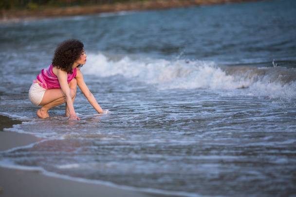 Young beautiful mixed race woman on the surf line at sea beach. - Photo, Image