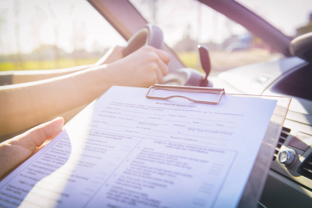 Examiner filling in driver's license road test form - Fotoğraf, Görsel