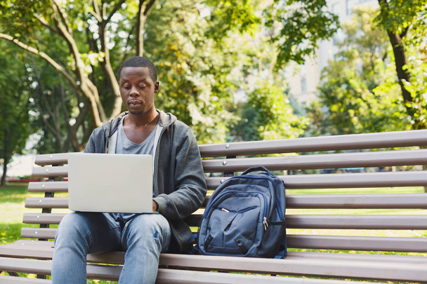 Konzentrierter Mann arbeitet draußen an seinem Laptop - Foto, Bild