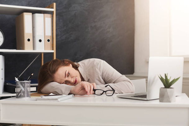 Втомлена бізнес-леді спить на робочому місці в офісі
 - Фото, зображення