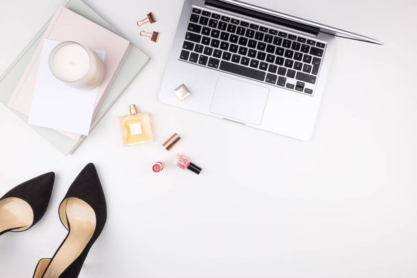 Office and fashion concept. Decorative cosmetics, shoes, laptop, - 写真・画像