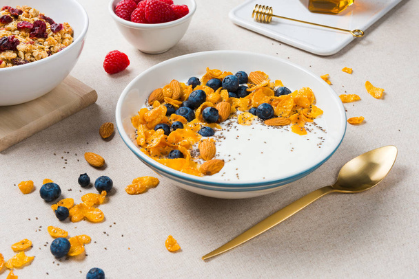 Corn flakes with yogurt, almonds, blueberries, raspberries and c - Photo, image