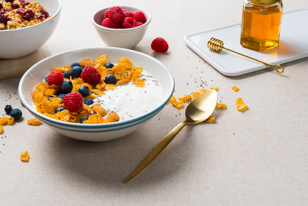 Corn flakes with yogurt, almonds, blueberries, raspberries and c - Zdjęcie, obraz