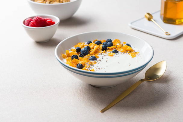 Corn flakes with yogurt, blueberries and chia seeds. - Zdjęcie, obraz