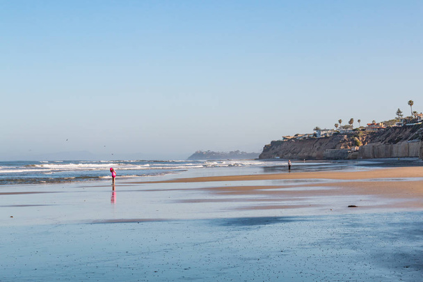 SOLANA BEACH, CALIFORNIA / Estados Unidos - 22 DE ABRIL DE 2018: Un niño pequeño está solo en la orilla de la marea baja en Fletcher Cove Beach Park en San Diego
. - Foto, Imagen
