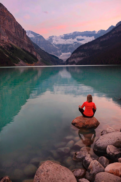 Paz interior. Meditación en el tranquilo Lago Louise al atardecer
.   - Foto, Imagen