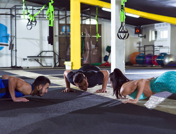 group of young healthy people doing pushups at crossfitness  gym - Foto, Bild