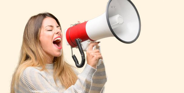 Молодая красивая женщина общается громко крича держа мегафон, выражая успех и позитивную концепцию, идею для маркетинга или продаж
 - Фото, изображение