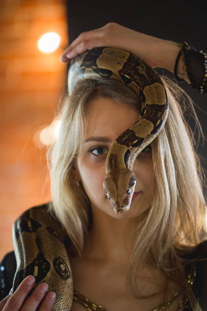 Portrait of beautiful young woman with a python on face - Photo, Image