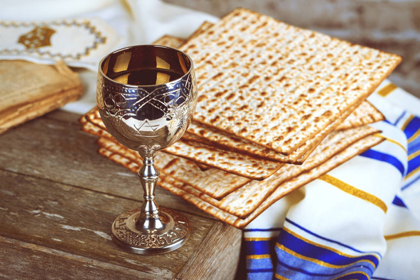 Pesach Passover symbols of great Jewish holiday. Traditional matzoh, matzah or matzo and wine in vintage silver plate and glass. - Photo, Image