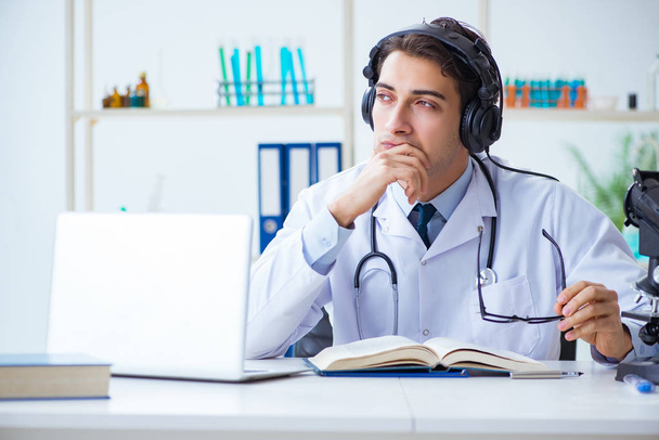 Αρσενικός γιατρός ακούγοντας τον ασθενή κατά τη διάρκεια τηλεϊατρικής συνεδρίας - Φωτογραφία, εικόνα