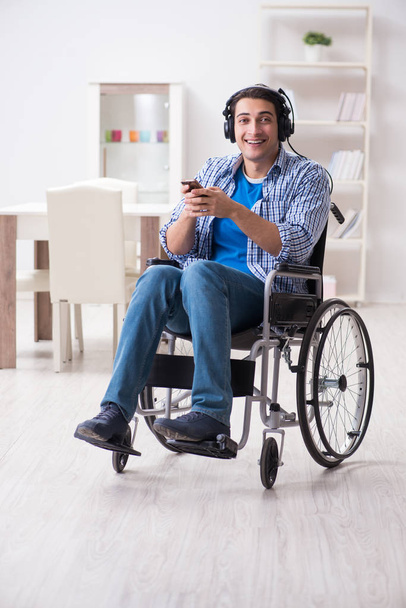 Disabled man listening to music in wheelchair - Фото, изображение