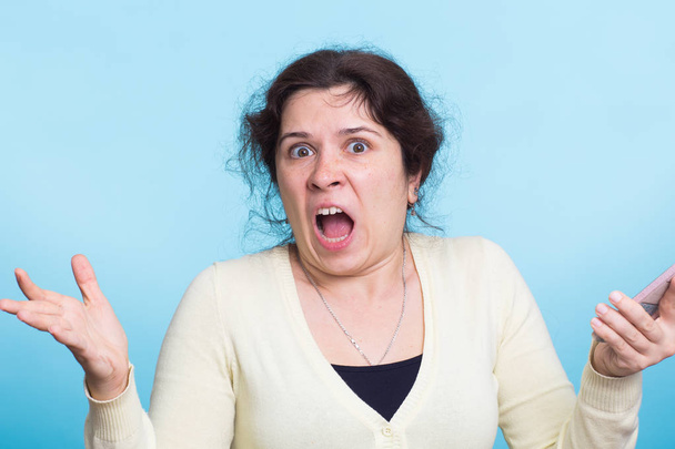 Mujer agresiva enojada sobre fondo azul
 - Foto, Imagen