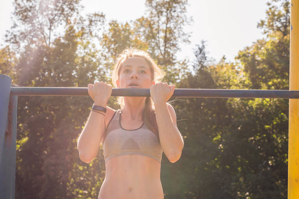Active and young woman doing pullups. - Photo, Image