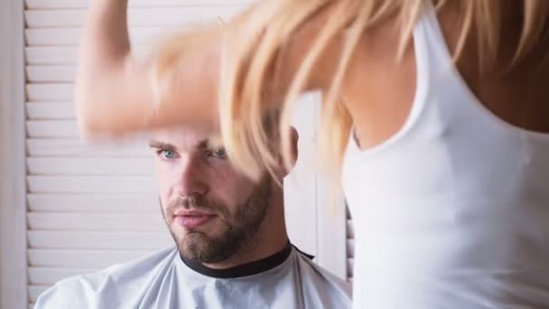 Mens haircut at the barber scissors. Great time at barbershop. Cheerful young bearded man getting haircut by hairdresser. Young Man in Barbershop Hair Care Service Concept. - Filmmaterial, Video