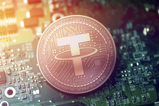 shiny copper TETHER cryptocurrency coin on blurry motherboard background - Photo, Image