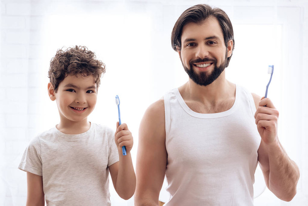 Adult father and son brush their together. - Foto, Imagem