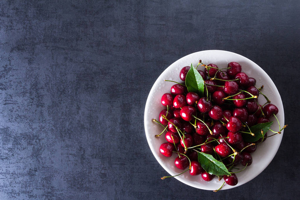 Fresh red ripe cherries on white plate - Fotografie, Obrázek