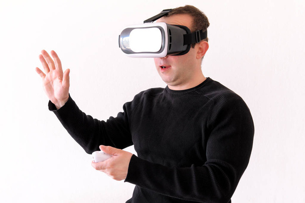 Beau homme portant et jouant la réalité virtuelle sur fond blanc isolé. Garçon action en réalité virtuelle casque. Lunettes VR. VR Box, casque VR. Jeune homme d'affaires au bureau et utilisant Vr Box
. - Photo, image