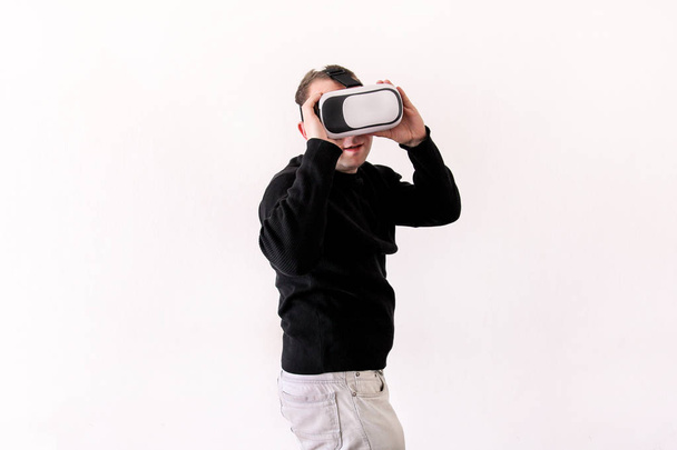 Όμορφος άνδρας φορώντας και το παιχνίδι εικονικής πραγματικότητας στο απομονωθεί σε λευκό φόντο. Αγόρι δράση στο κράνος εικονικής πραγματικότητας. VR γυαλιά. VR πλαίσιο, ακουστικό Vr. Νεαρός επιχειρηματίας στο γραφείο και χρησιμοποιώντας πλαίσιο Vr. - Φωτογραφία, εικόνα