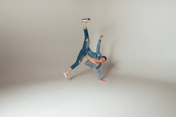 shot of jump feet up, of mad, crazy, cheerful, successful, lucky guy in casual outfit, jeans, jumping with hands up,triumphant, gesturing against white background - Photo, image