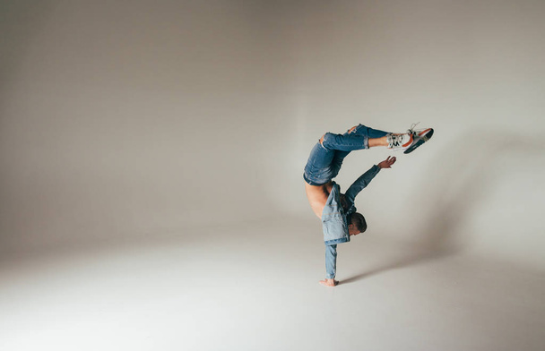 shot of jump feet up, jump, stand on one's hands, of mad, crazy, cheerful, successful, lucky guy in casual outfit, jeans, jumping with hands up,triumphant, gesturing against white background - Fotó, kép