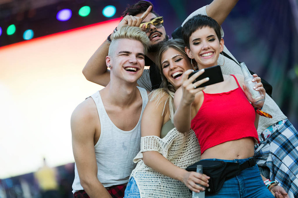 Happy young friends having fun at music festival - Фото, изображение