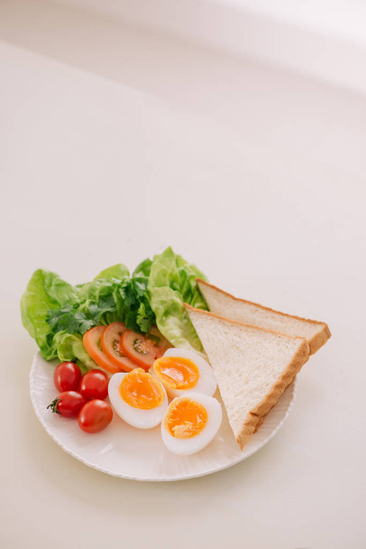 Свіжий садовий салат з яйцями, авокадо і помідорами в коричневій тарілці для здорового низькокалорійного обіду
. - Фото, зображення