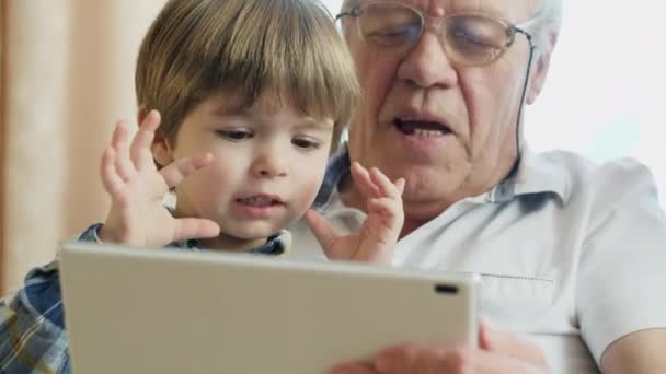 Dziadek za pomocą cyfrowego tabletu z wnukami - Materiał filmowy, wideo