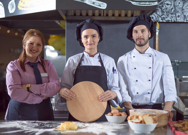 Retrato de chefs de grupo de pie juntos en la cocina comercial en el restaurante - Foto, imagen