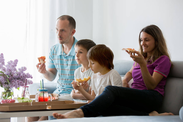 Beautiful young family with children, eating pizza at home and w - Фото, изображение