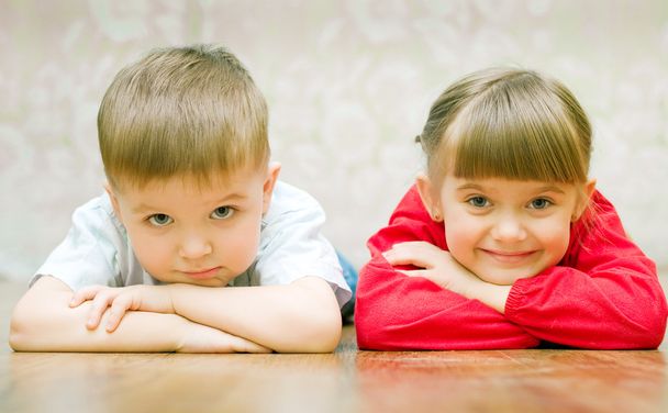 Funny boy and a girl lying on the floor - Foto, Bild