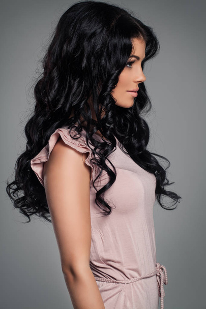 Модель моды для брюнеток. Молодая женщина со здоровыми вьющимися волосами
 - Фото, изображение