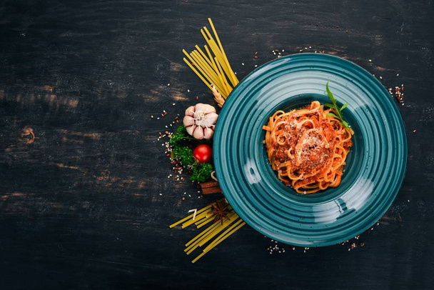 Linguine Pasta with tomatoes. On a wooden background. Italian cuisine. Top view. Copy space. - Fotó, kép