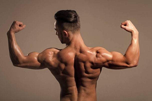 Athletic bodybuilder man on grey background - Foto, imagen