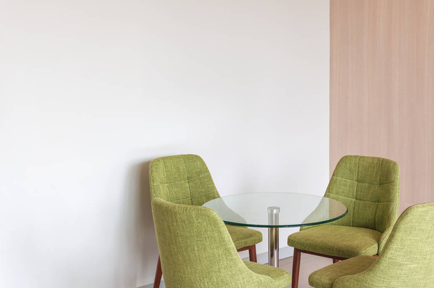 Zbliżenie zielony fotel nowoczesny styl na tle białego rogu betonu  - Zdjęcie, obraz