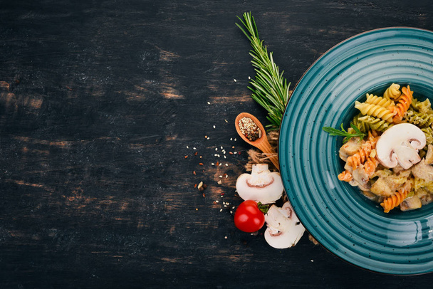 Pasta with mushrooms and chicken. On a wooden background. Italian cuisine. Top view. Copy space. - 写真・画像